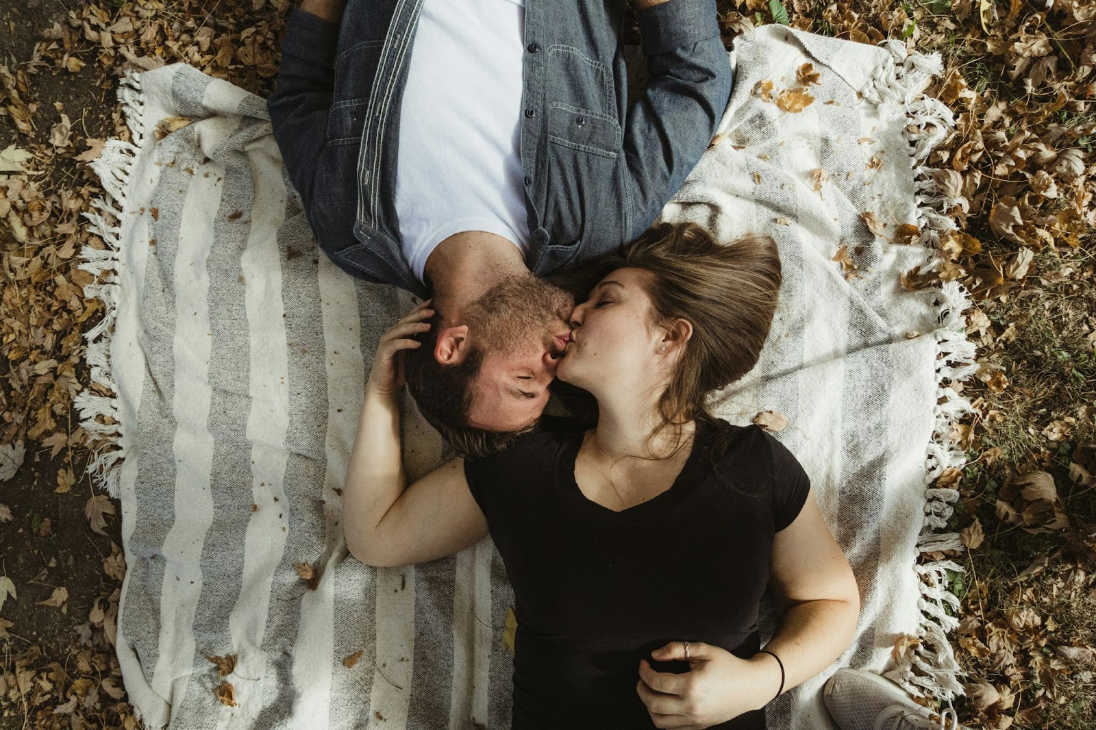 A man and woman laying on the ground.