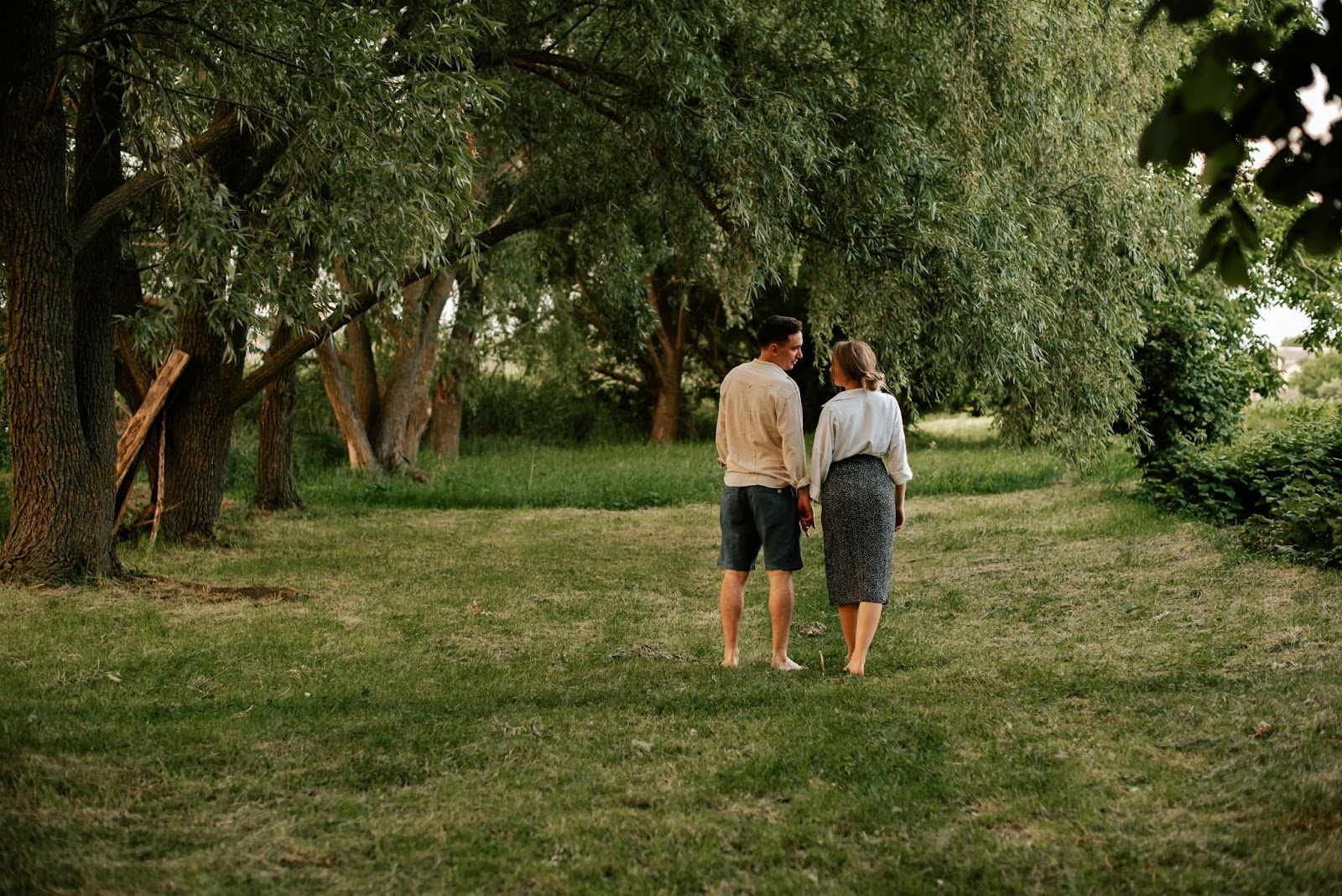 A man and woman walking at the grass.