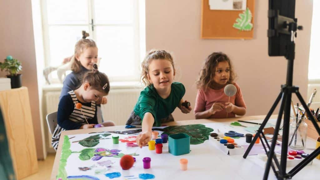 A group of kids painting and crafting at a table.
