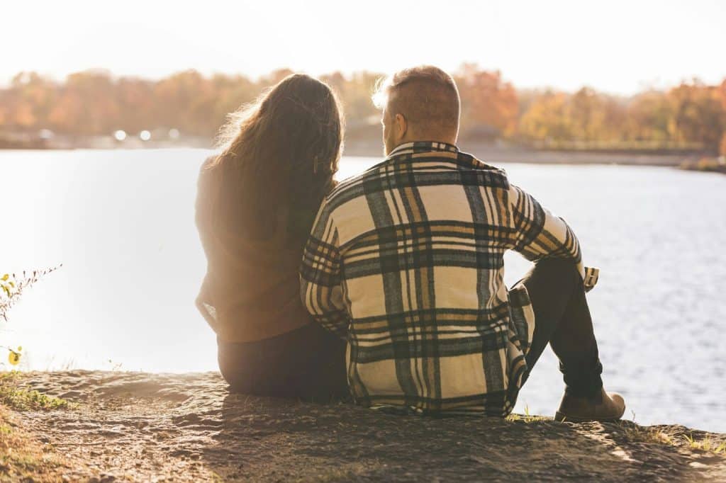 A man and woman sitting at the rock