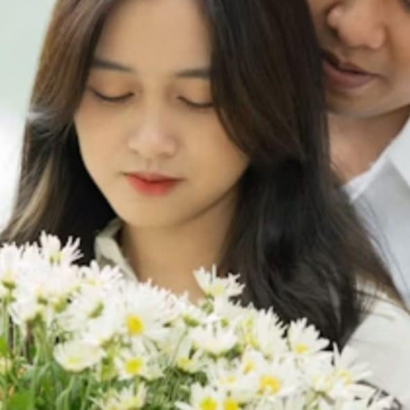 A man giving flowers while a woman appears unimpressed