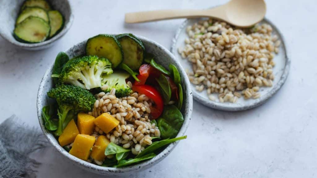 A bowl of mixed vegetables and grains on a table.