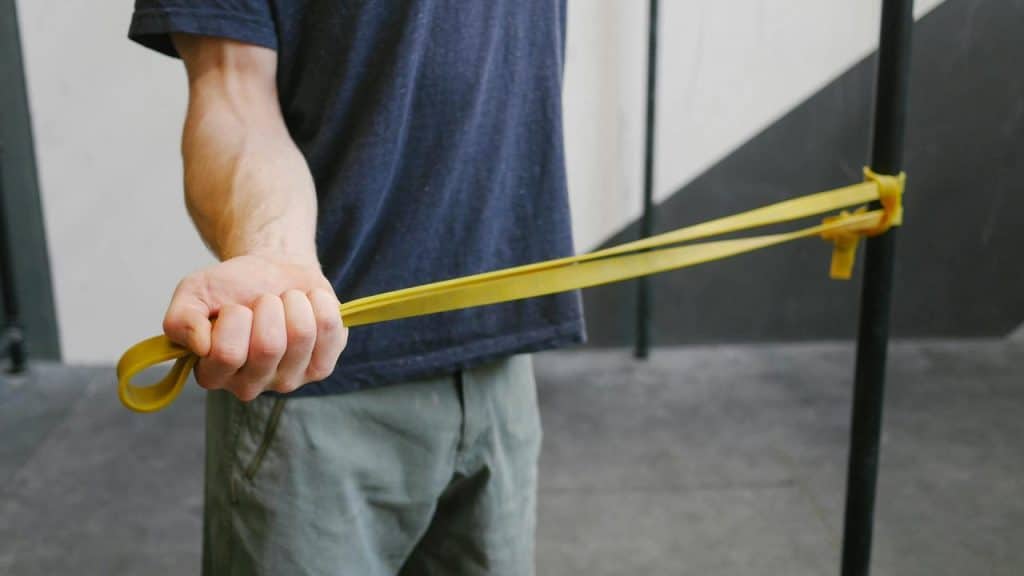 A man doing resistance band exercises with a yellow band.