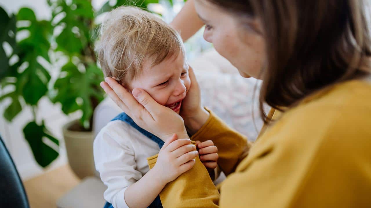 A mother comforting her crying child.
