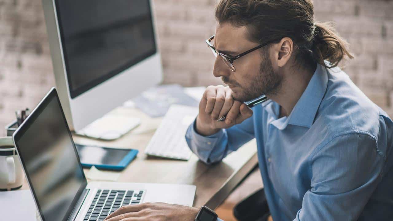 A man working on a laptop at his desk.