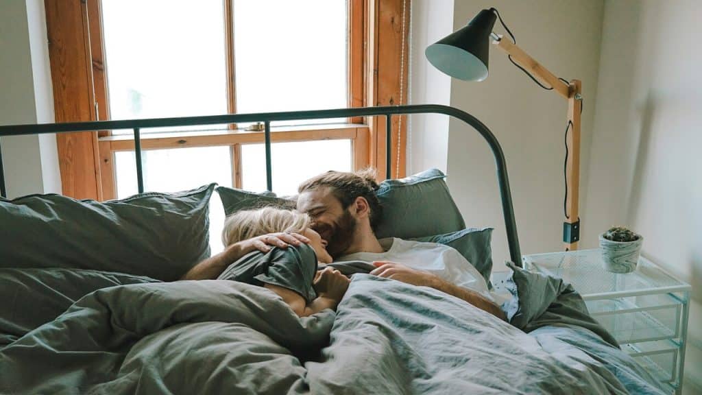A couple cuddling in bed.