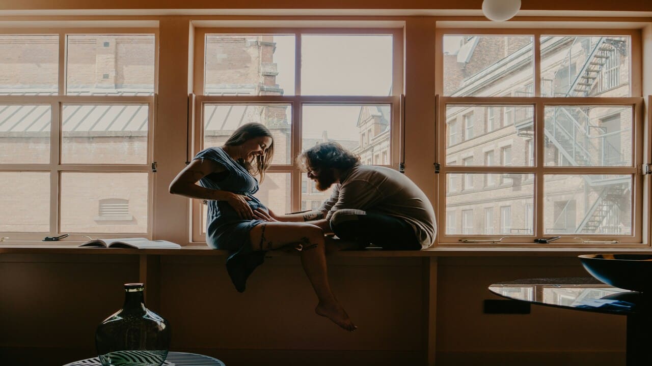 A man talking to his pregnant wife’s tummy.