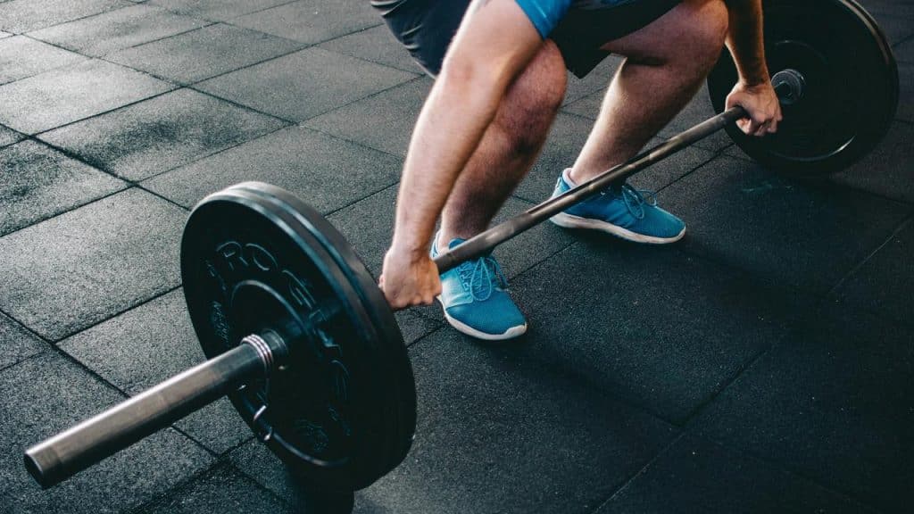 A man preparing to lift a barbell at the gym.
