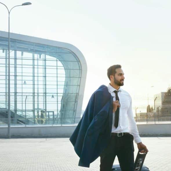 A man in business attire with a suitcase.