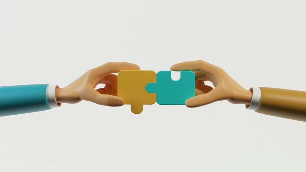 Hands holding two puzzle pieces together.