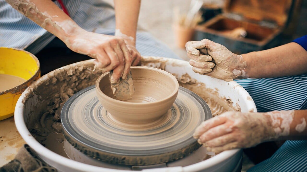 Two people doing pottery.