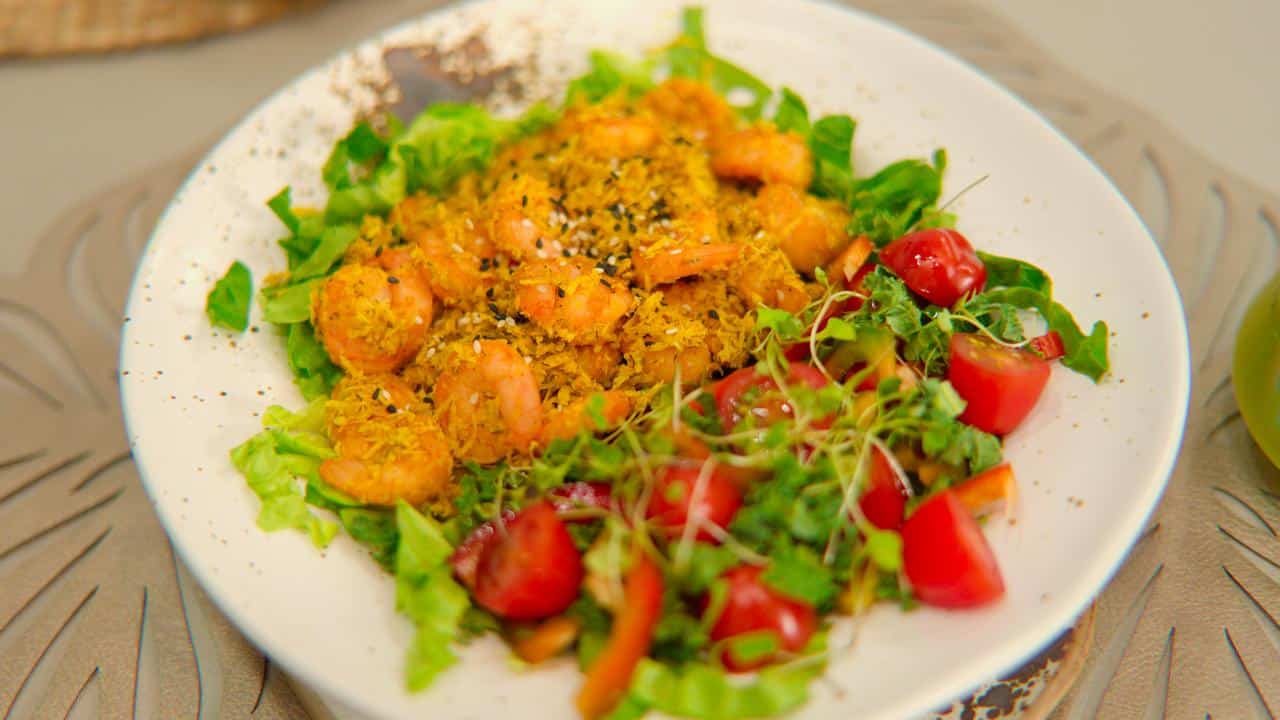 A salad with shrimp, cherry tomatoes, and greens.