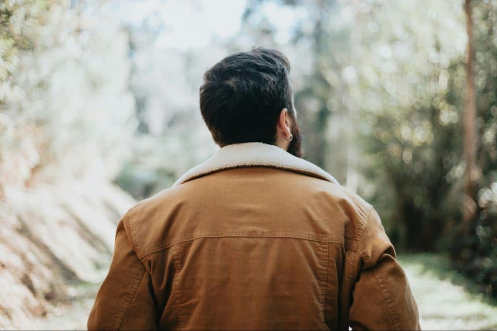 A man walking in the forest while taking realizations 