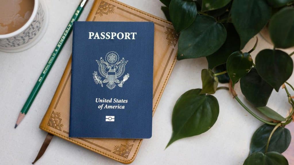 A United States passport on top of a brown journal.