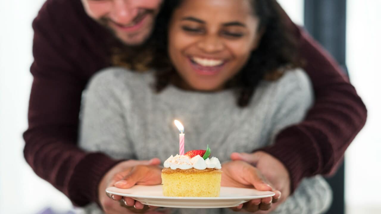 A man presenting a cake to his girl.