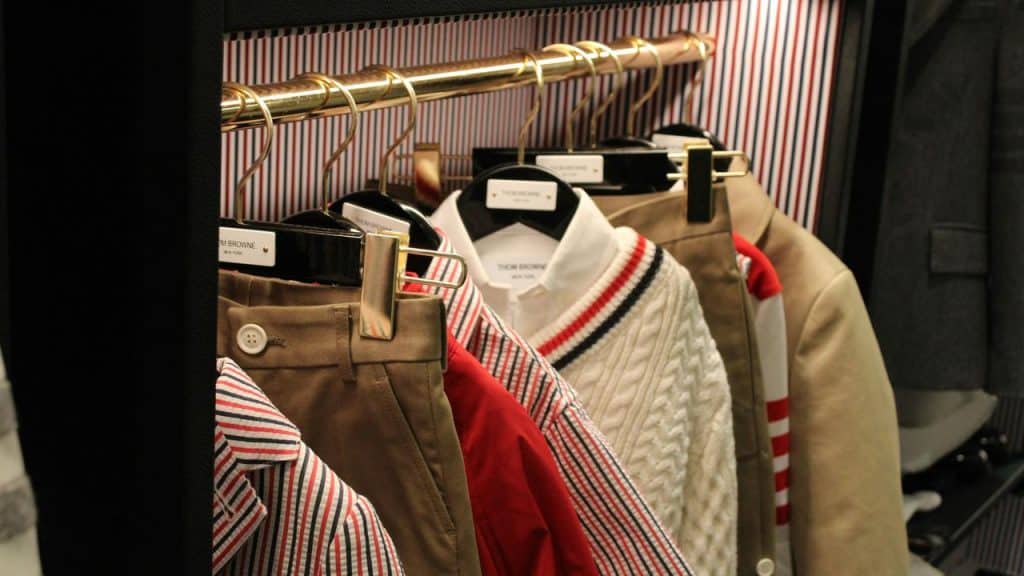 A rack of neatly hung designer clothes in a closet.