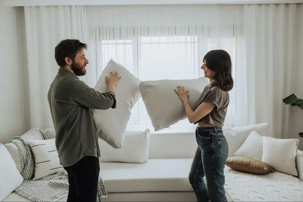 A man and woman holding a pillow