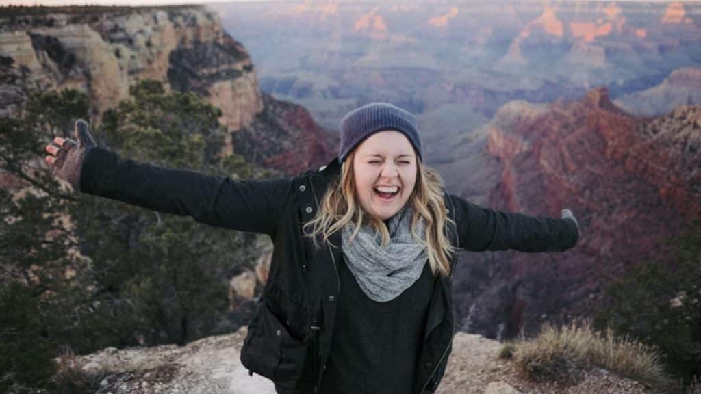Woman on top of a mountain with her arms outstretched