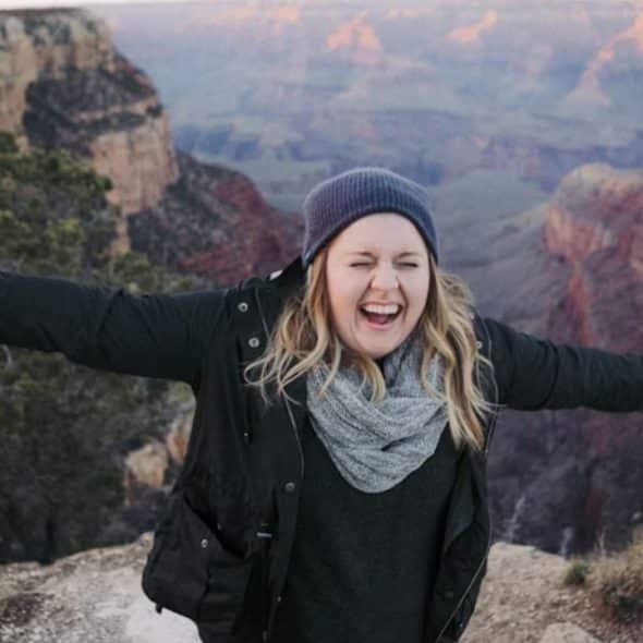 Woman on top of a mountain with her arms outstretched