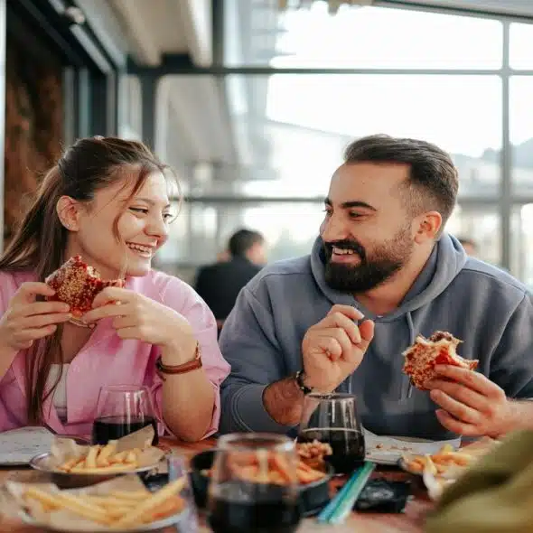 A couple laughing during a pizza date.