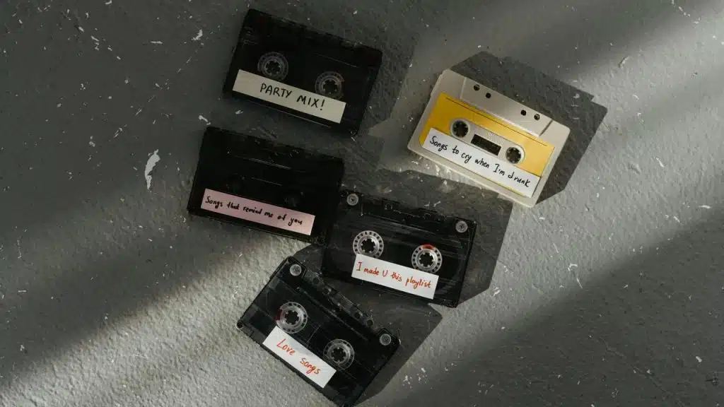 A collection of labeled cassette tapes on a gray floor.