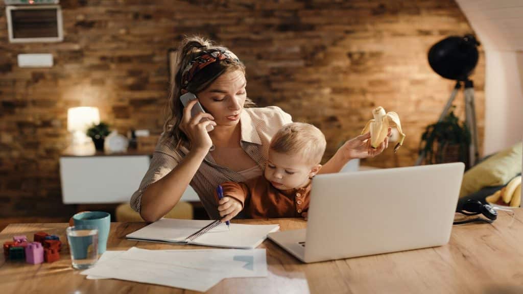 A mom working while taking care of her baby.