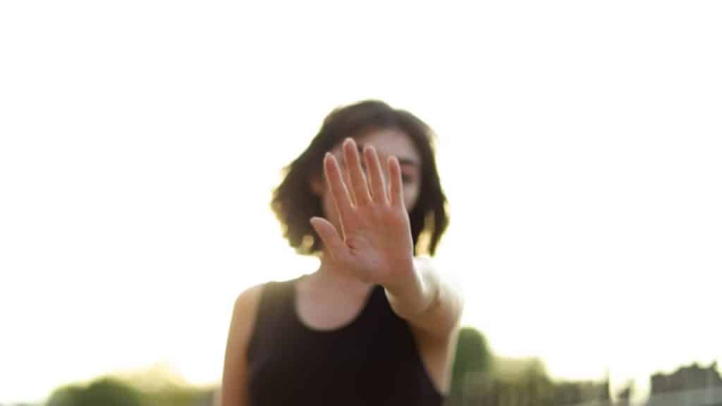Woman raising a hand to signal “stop”