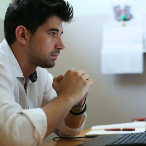 Man looking thoughtful while checking bills on his laptop