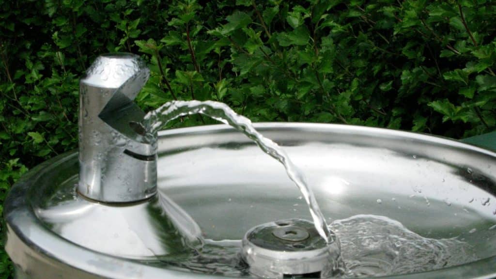 A water fountain with water flowing from the spout.