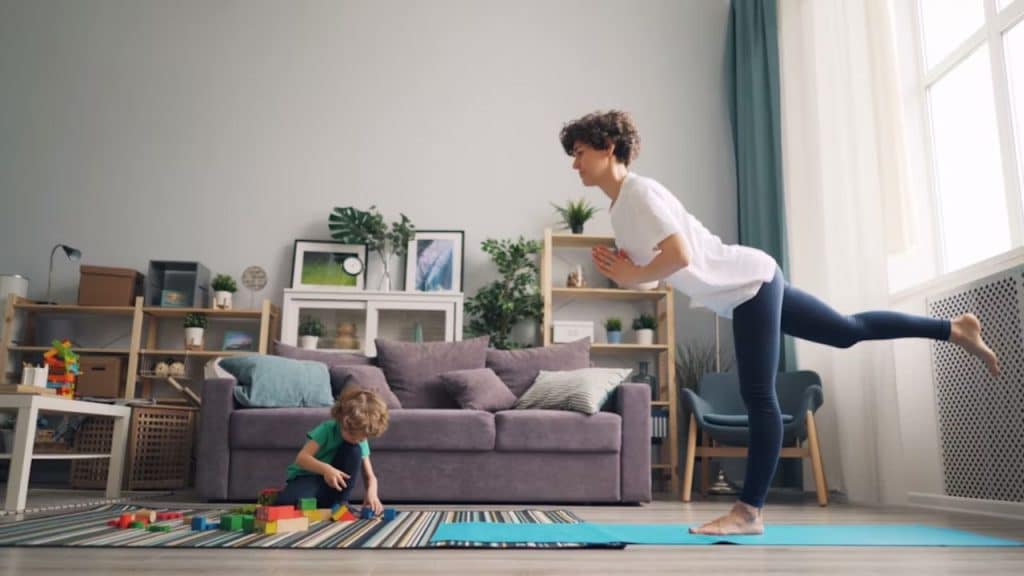 Woman exercising while taking care of her child