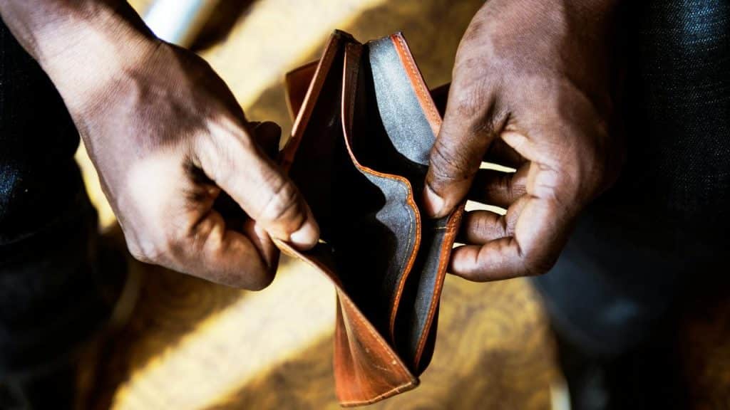 A person holding an open empty wallet.