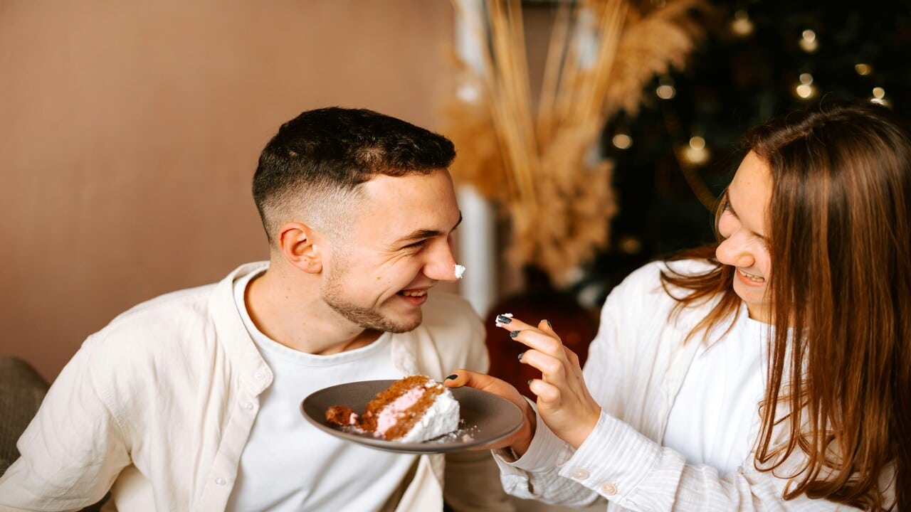 A couple eating cake together.