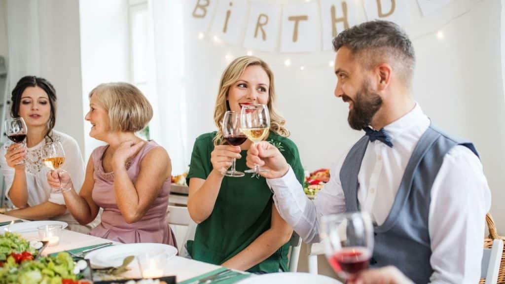A group of people are raising their glasses for a toast at a birthday party.