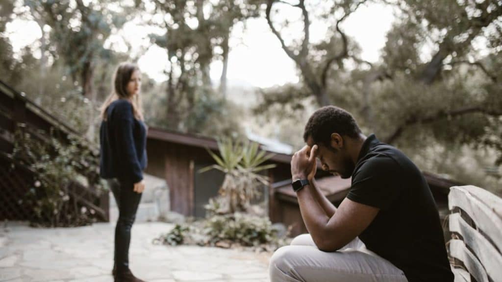 Man in messy clothes with unkempt appearance while wife looks disappointed