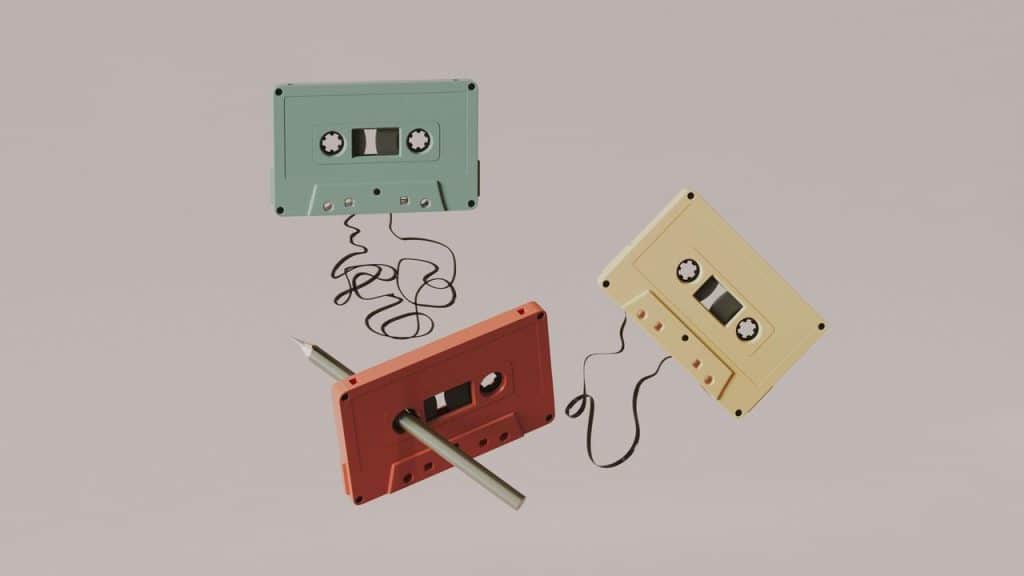 A set of colorful cassette tapes with loose tape unraveling.