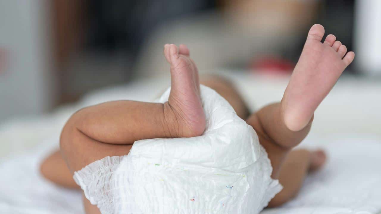 A baby lying down in a diaper.
