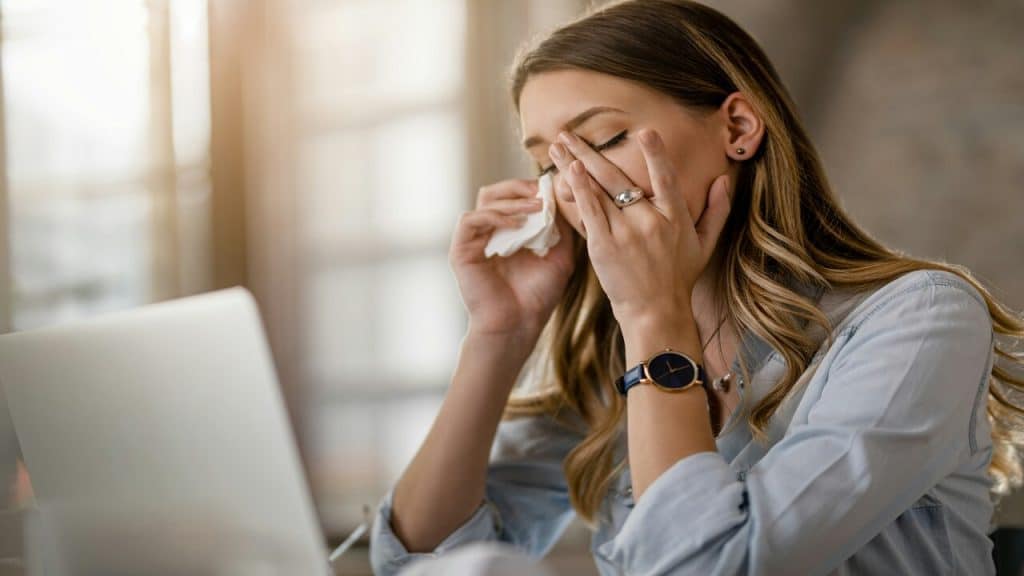 A woman looking sick while working from home.