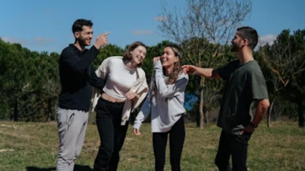 Wife laughing with friends while husband looks left out