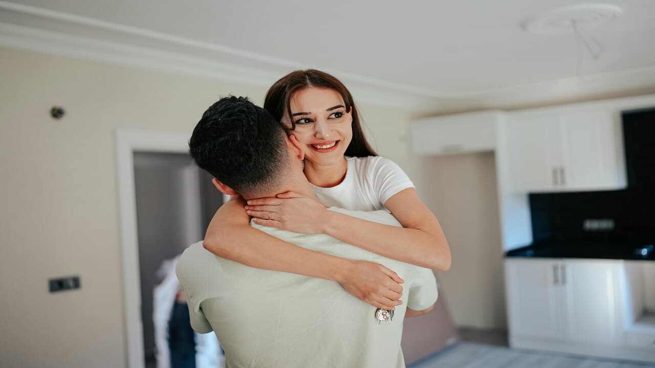 A couple hugging in the kitchen.