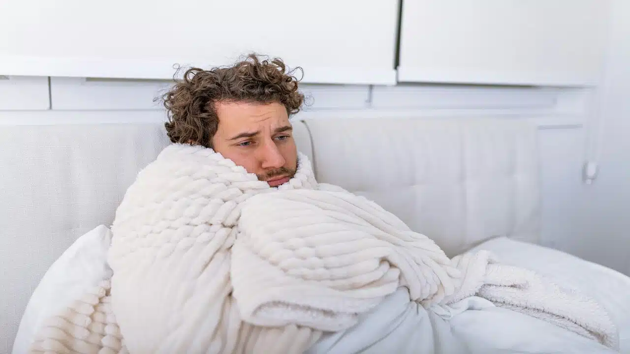 A man looking sad in bed.