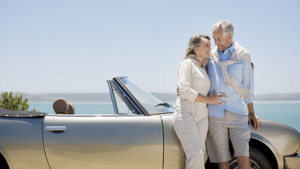 A mature couple next to a car
