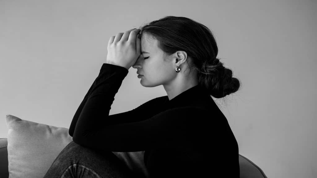 A woman looking sad on the couch
