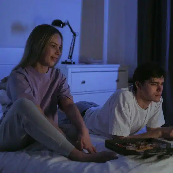 A man and woman watching a movie together.
