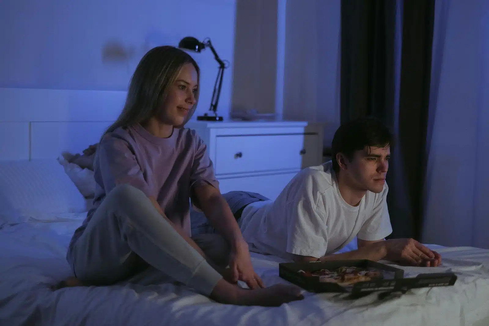 A man and woman watching a movie together.