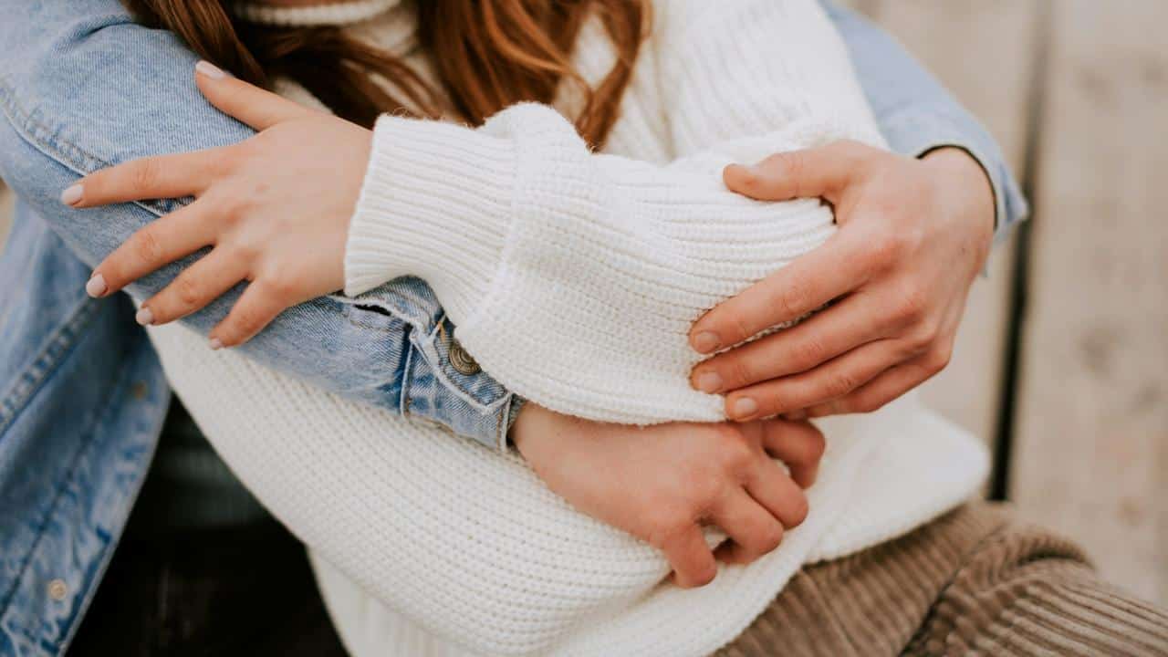 A close-up of two people hugging tightly.