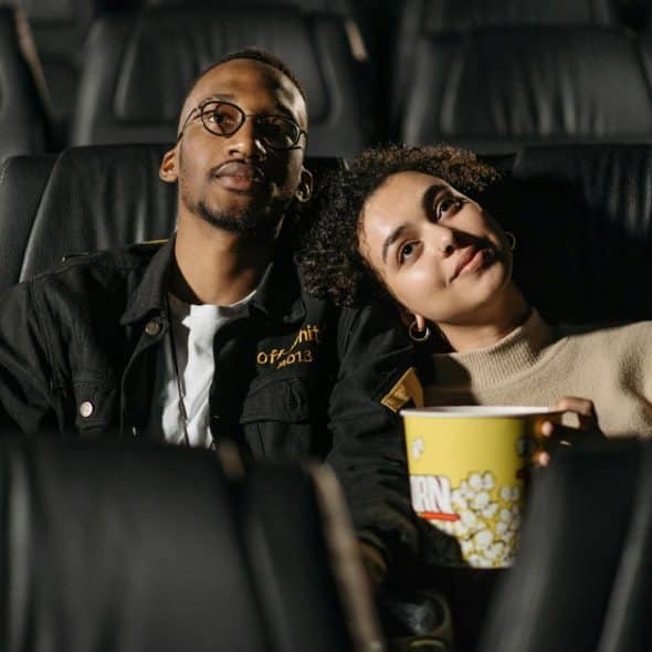 A man and woman watching a movie together.