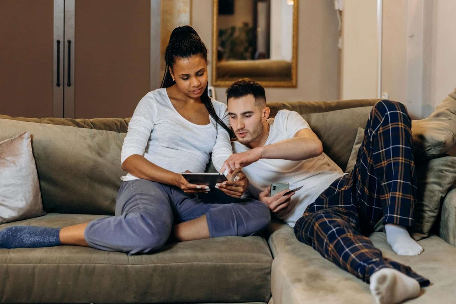 A man and woman viewing something on the tablet.