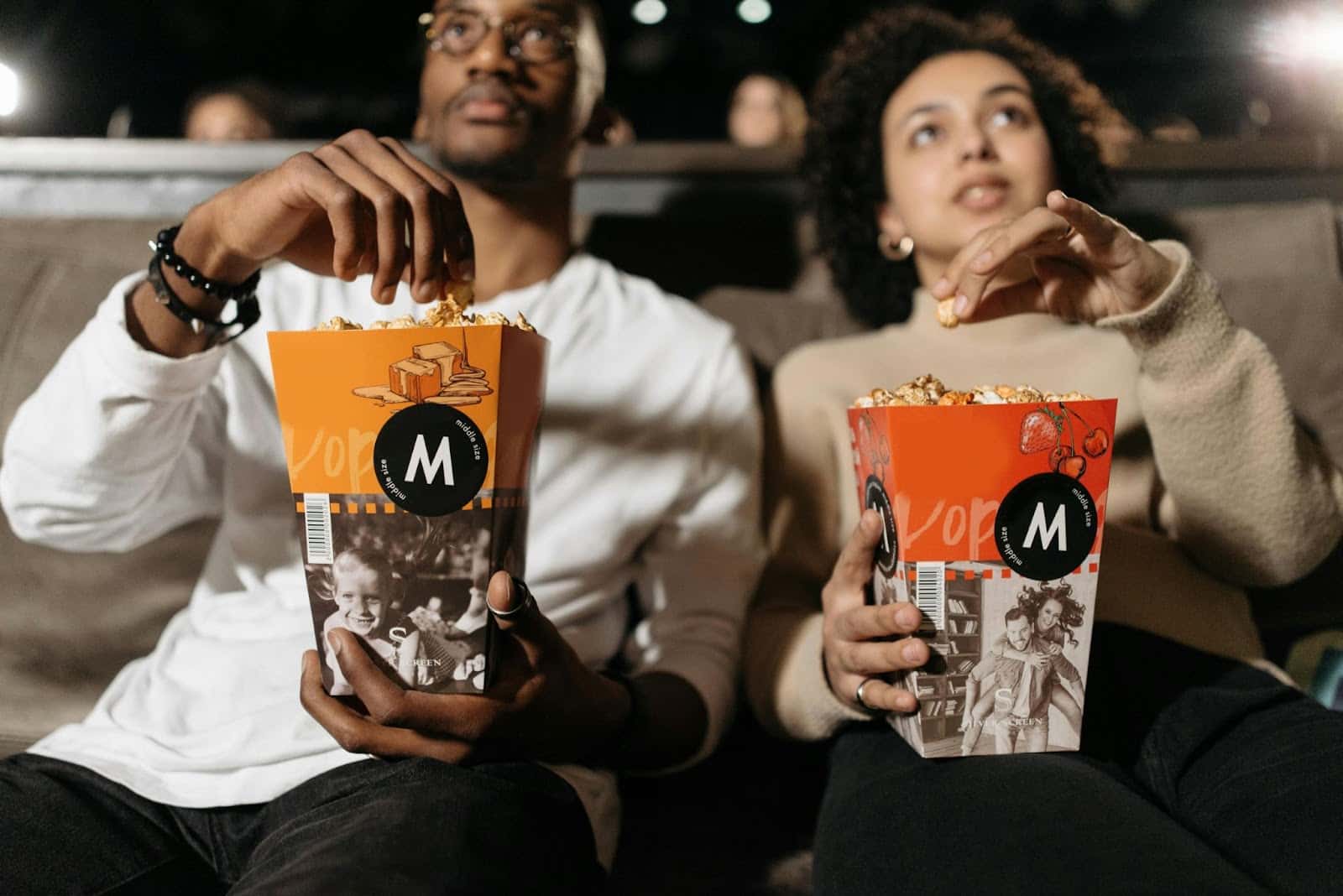 A man and woman having their own snacks.