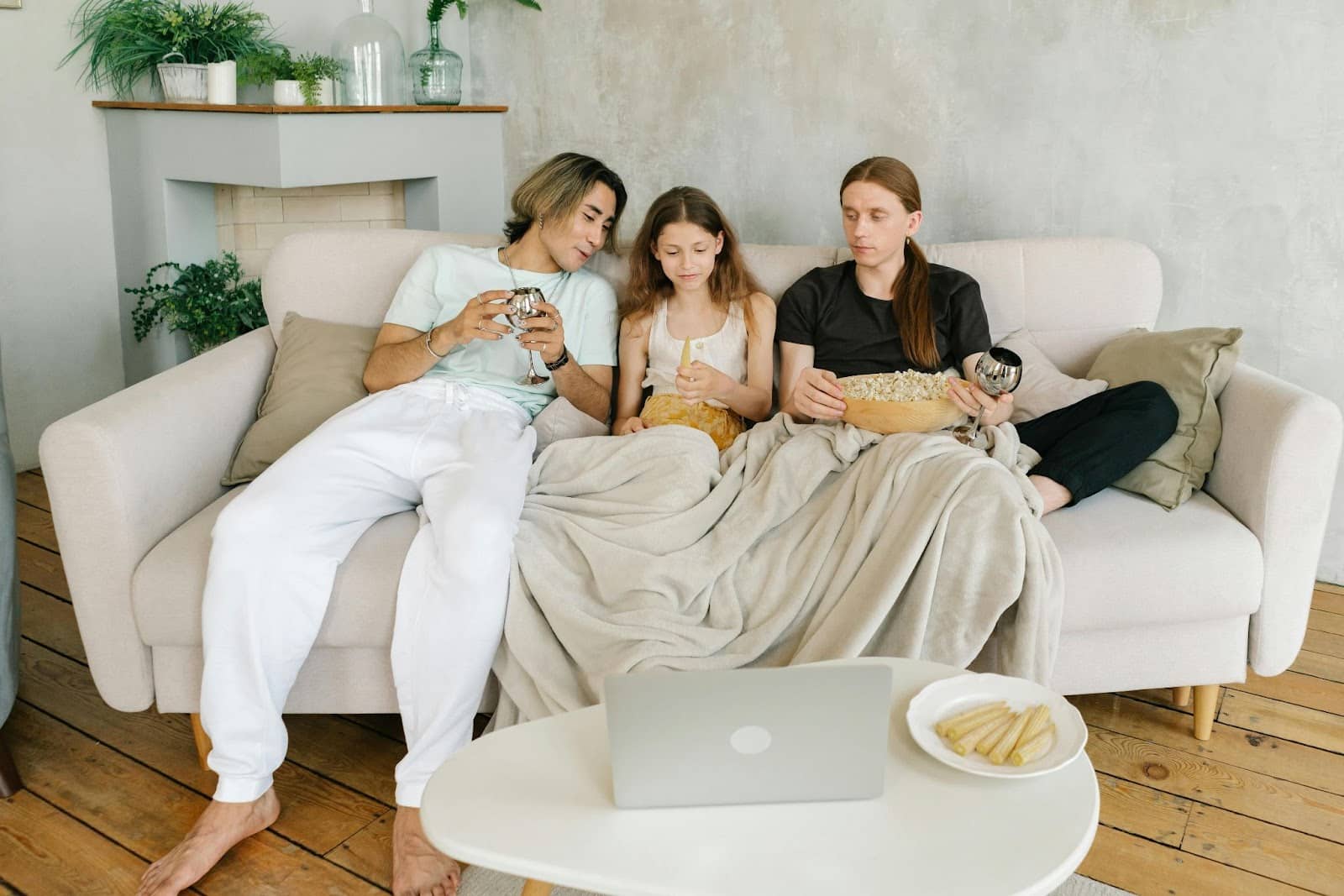 A comfortable man and woman with their child binge-watching.