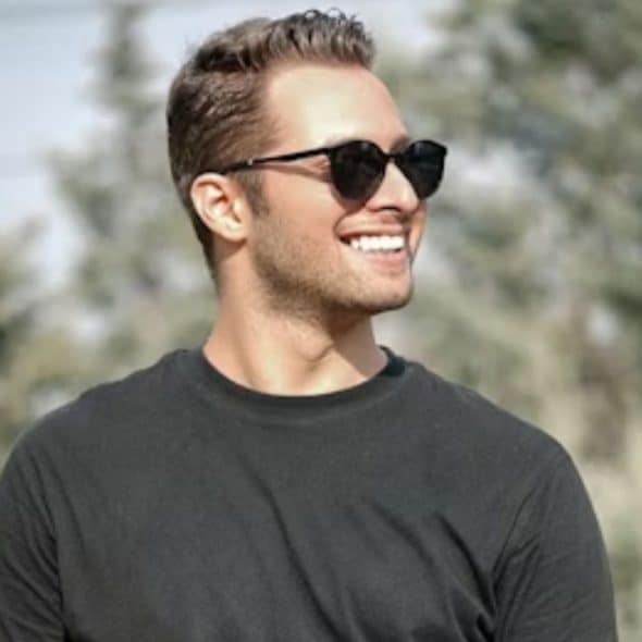 Confident man walking outdoors with relaxed posture and natural smile